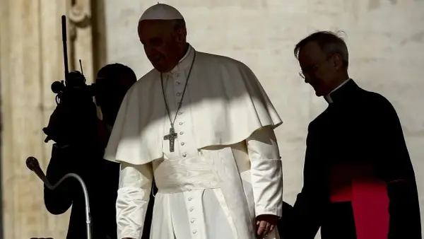 Papst Franziskus, der sich gegen Abtreibung ausspricht, geht mit einem Begleiter.